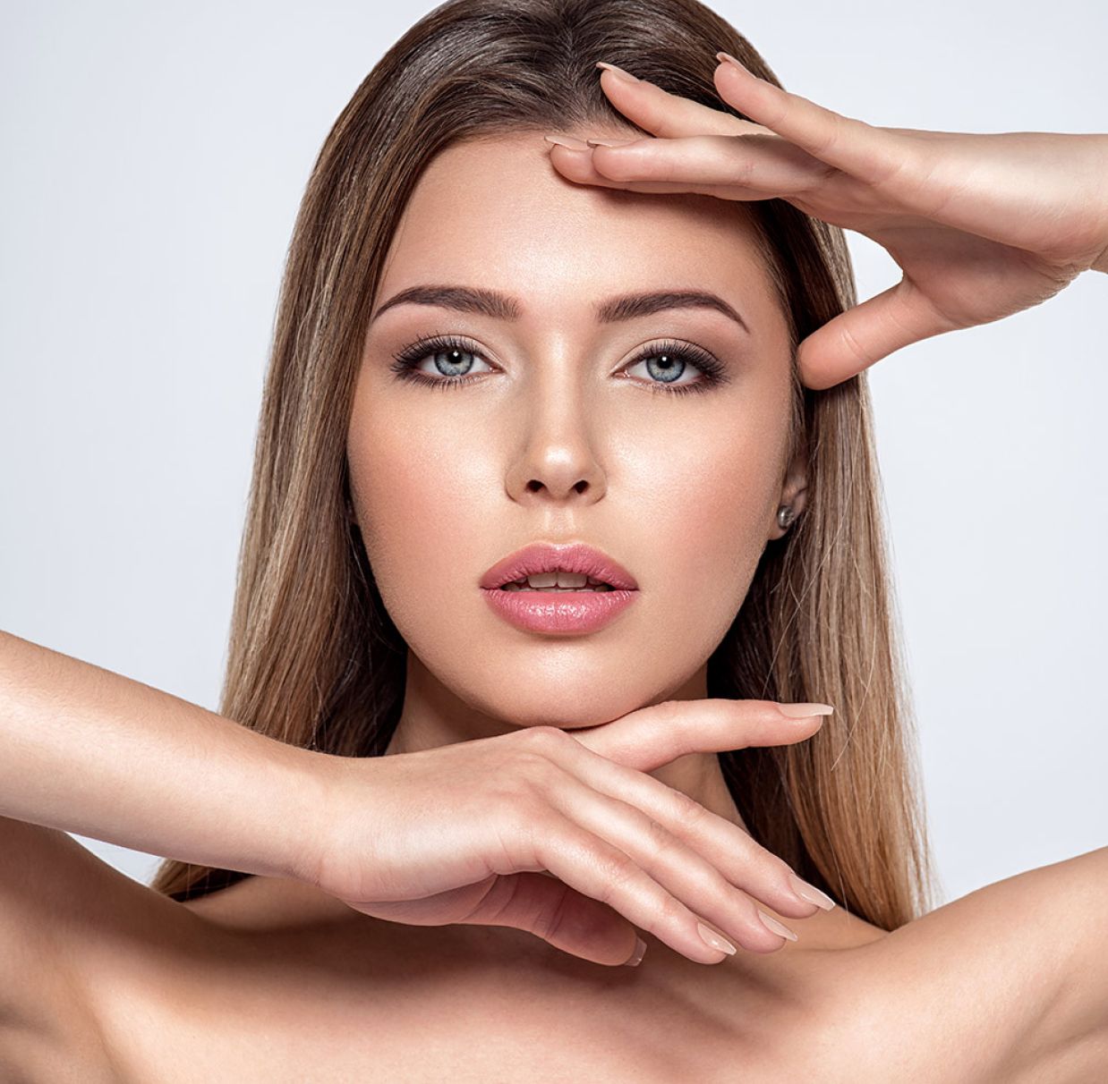 beauty face of young woman with hands above and below face