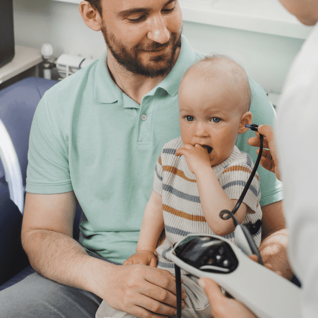 Baby having their ears checked during an ENT exam
